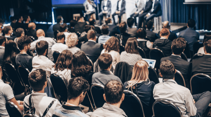 Conference audience watching a panel discussion on stage — professional conference management and delegate experience delivered by KnotArt across New Zealand
