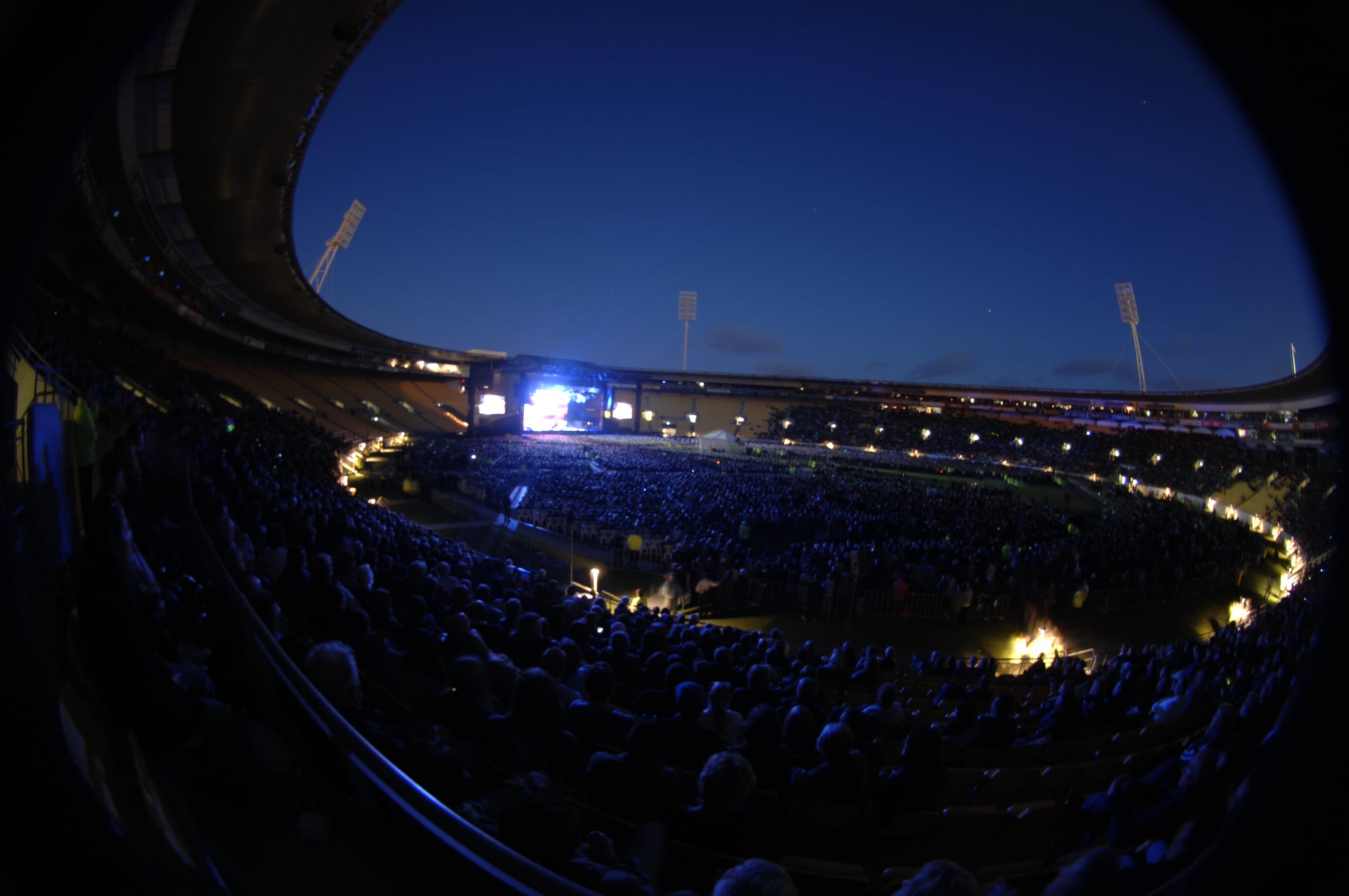 Wide night view of Elton John performing to a large crowd at Westpac Stadium in Wellington.